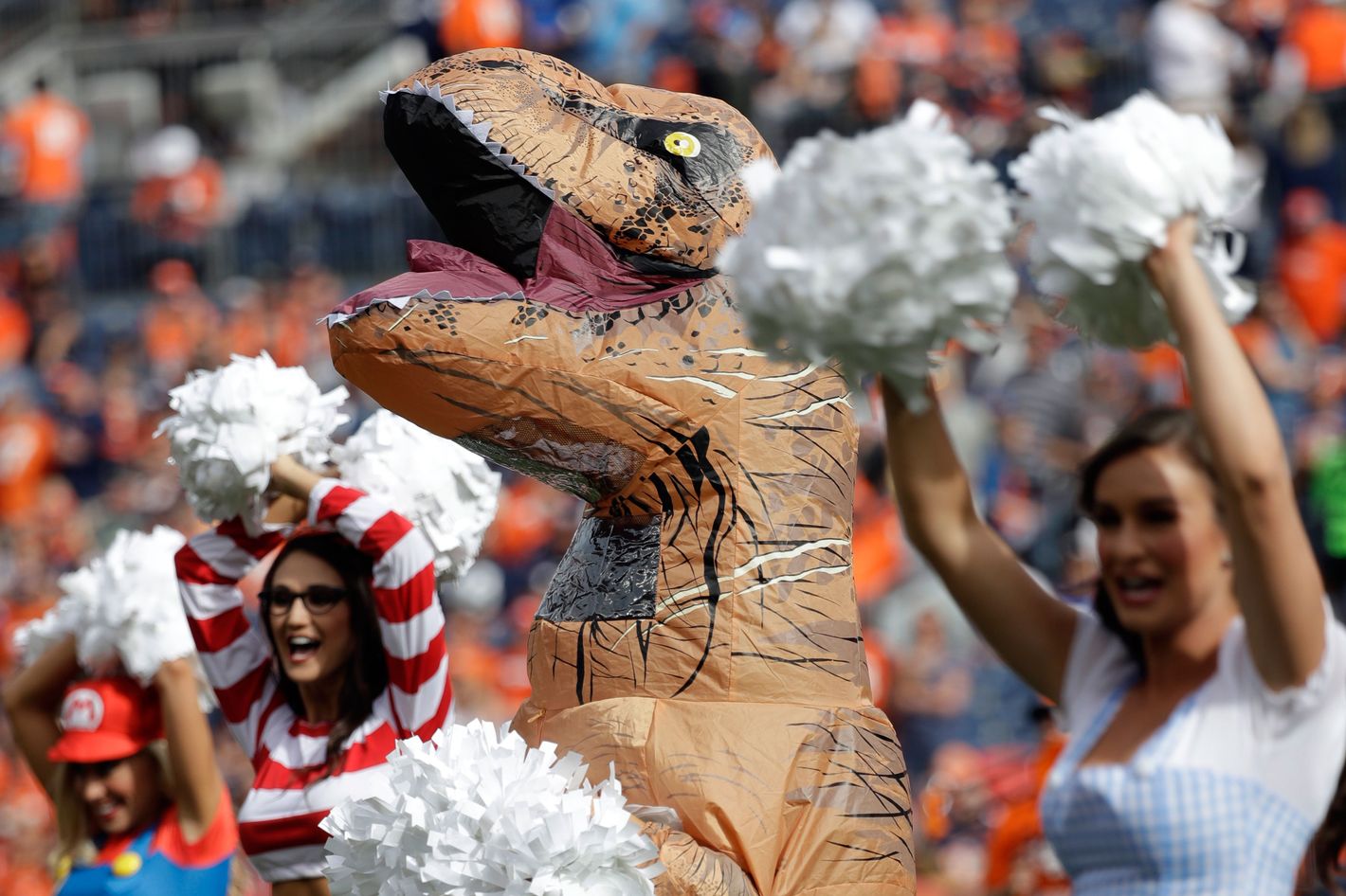 Broncos Cheerleader Romi Bean Wears Inflatable T-Rex Costume