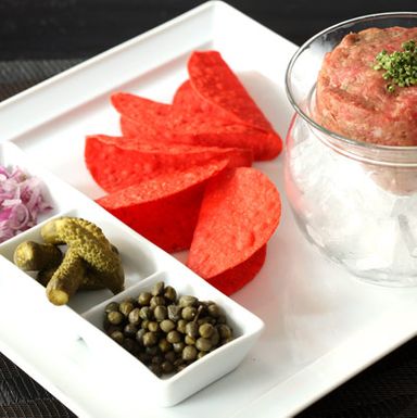 Ground raw filet mignon, capers, onions, cornichons, mini taco shells