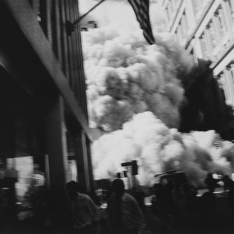 Smoke and debris rushes through the Wall Street area near Trinity Church, after the first tower collapses during the World Trade Center attack.