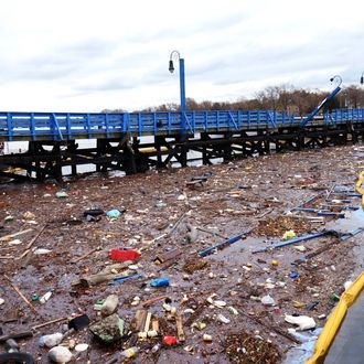 November 01,2012.Workman setup a fuel containment barrier by orders of the U.S. Coast Guard. Hurricane Sandy turned over boats that spilled diesel fuel in Sheepshead Bay.Debris and diesel fuel mix together in Sheepshead Bay.