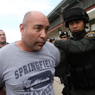 Joseph Manuel Hunter, left, is led by Thai police commandos to Police Aviation Division after being arrested, in Bangkok, Thailand, Thursday, Sept. 26, 2013. Thai police said they arrested the American man wanted by the U.S. for allegedly running a drug trafficking network that spanned Asia and the United States. Hunter was arrested Wednesday on the resort island of Phuket as part of a sting operation launched at the request of the U.S. Drug Enforcement Agency. (AP Photo/Sakchai Lalit)