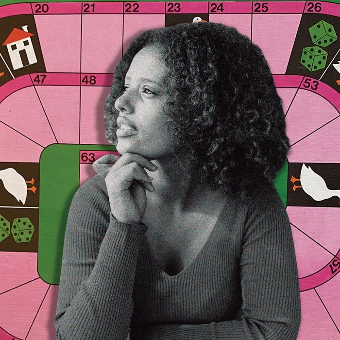 A woman with curly hair squints as she looks thoughtfully to her right, resting her chin on the knuckles of her right hand.