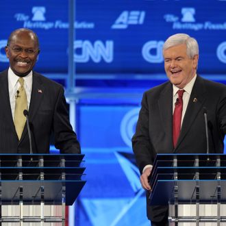 Former House speaker Newt Gingrich (R) and US businessman Herman Cain (L) laugh following an exchange during the Republican presidential debate on national security November 22, 2011.