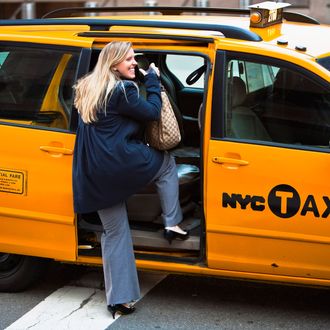 A woman is hailing a yellow cab on Lower Manhatten on March 10, 2010 in New York, New York.