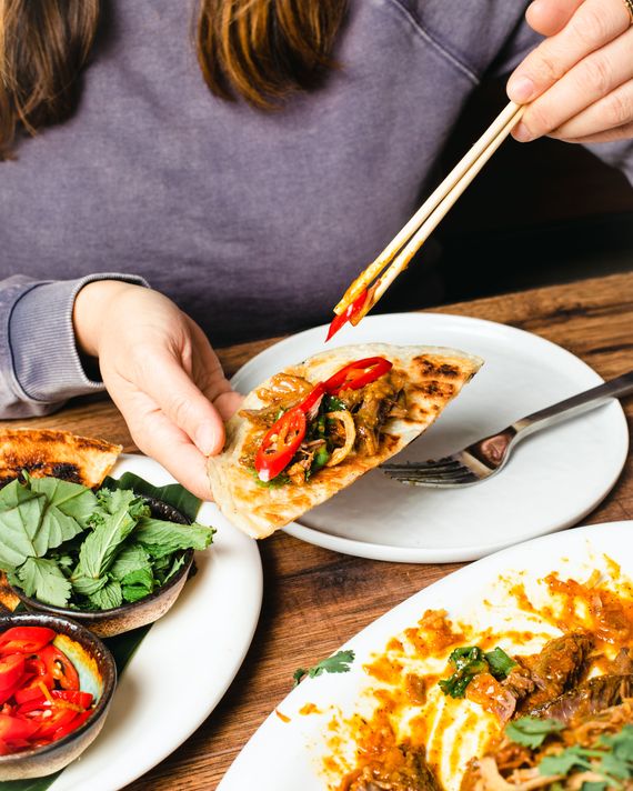 Close-up of a woman assembling a lamb rendang
