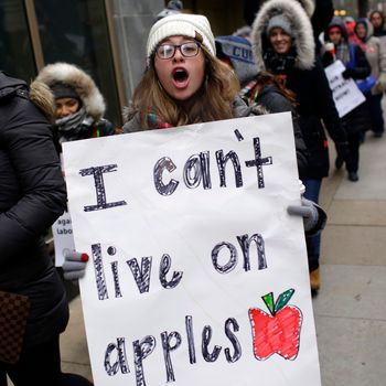 Educators from the Acero charter school network hold signs as they protest during a strike outside Chicago Public Schools headquarters on December 5, 2018 in Chicago, Illinois.