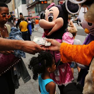 NEW YORK, NY - JULY 28: Costumed street performers receive tips from the public after posing for pictures in Times Square on July 28, 2014 in New York City. In the latest incident involving the often aggressive characters, a man dressed as Spider-Man allegedly punched an officer in the face over the weekend following a dispute with a woman over a tip, police have said. The Times Square Alliance is now calling for strict licensing of costumed street performers. (Photo by Spencer Platt/Getty Images)