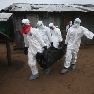 A Liberian burial team wearing protective clothing retrieves the body of a 60-year-old Ebola victim from his home on August 17, 2014 near Monrovia, Liberia. The epidemic has killed more than 1,000 people in four African countries, and Liberia now has had more deaths than any other country.