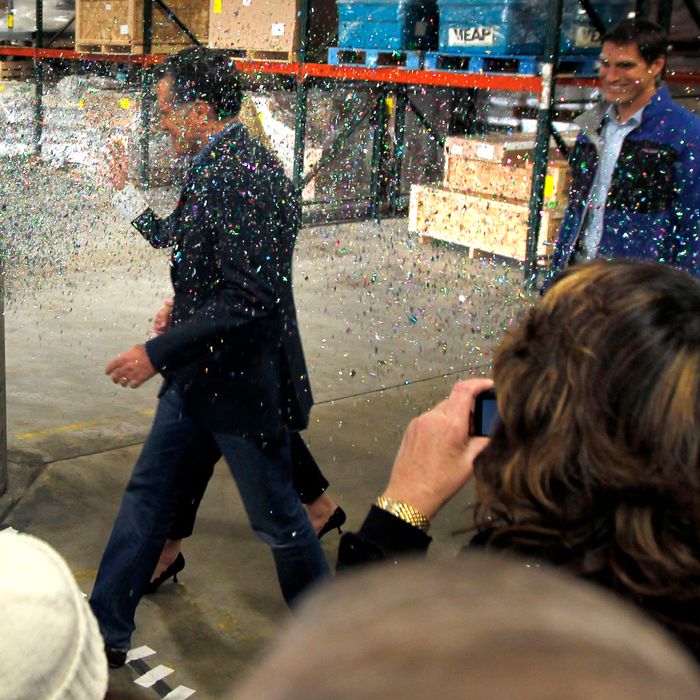 A gay rights activist, not pictured, throws a cup of glitter on Republican presidential candidate, former Massachusetts Gov. Mitt Romney as he walks to the stage at the start of a campaign rally in Eagan, Minn., Wednesday, Feb. 1, 2012. (AP Photo/Gerald Herbert)