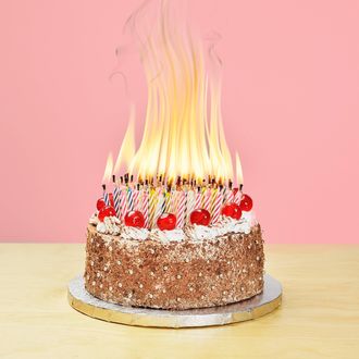 100 birthday candles burning on a cake