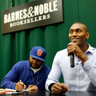 Heddrick McBride (L) and NBA player Metta World Peace sign copies of their children's book 