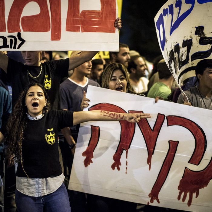Right wing activist hold signs calling for revenge during a protest on October 23, 2014 in Jerusalem, Israel. The protest took place at the site of the terror attack.
