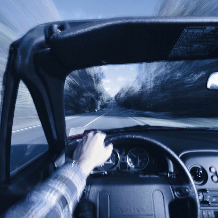 Man driving convertible sports car (blurred motion)