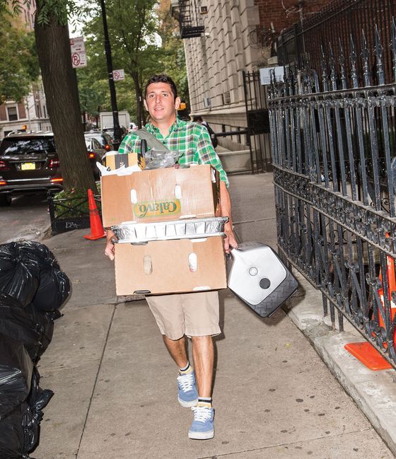 Saffer carrying boxes of supplies, plus a cooler to hold the oysters.