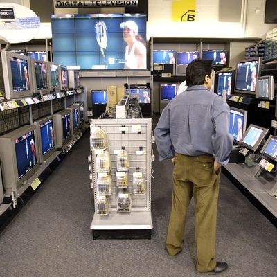 A shopper looks at televisions at Best Buy April 1, 2003 in Chicago. Best Buy announced lower fourth quarter earnings earlier in the day and cut first quarter projections.