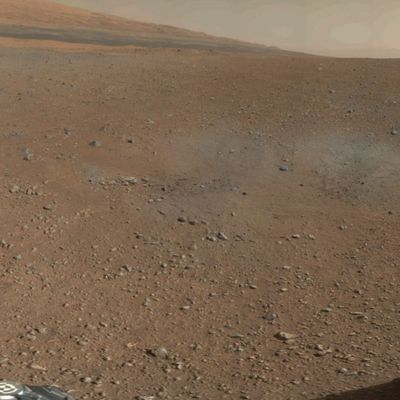 In this handout image provided by NASA and released on August 9, 2012, a color image from NASA's Curiosity Rover shows the pebble-covered surface of Mars. This is a portion of the first color 360-degree panorama from NASA's Curiosity rover, made up of thumbnails, which are small copies of higher-resolution images. The mission's destination, a mountain at the center of Gale Crater called Mount Sharp, can be seen in the distance, to the left, beginning to rise up. The mountain's summit will be imaged later. Blast marks from the rover's descent stage are in the foreground.