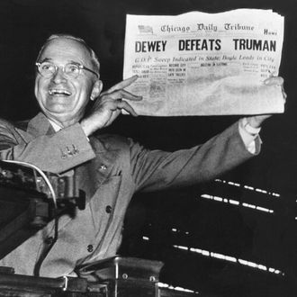 Victorious presidential candidate Pres. Harry Truman jubilantly displaying erroneous CHICAGO DAILY TRIBUNE w. headline DEWEY DEFEATS TRUMAN which overconfident Republican editors had rushed to print on election night, standing on his campaign train platform.