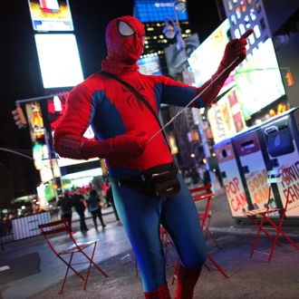 A man costumed as Spiderman chats with Gregg Deal as he walks around Times Square in Manhattan, NY, dressed in Native American garb on November 05, 2013. Deal is an American Indian street artist living in the Washington, DC area, who has undertaken projects that use stereotypes to discover how others view and interact with Native American culture.