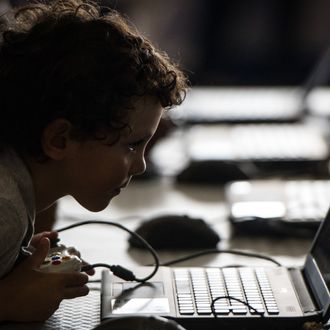 A boy plays a game on a laptop compuer at the IT event 