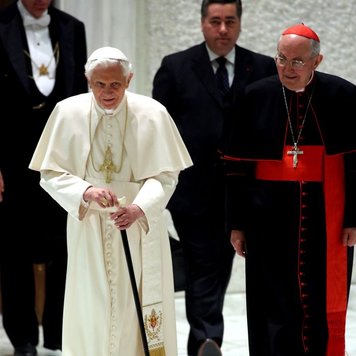Pope Benedict XVI, flanked by cardinal Agostino Vallini, arrives at the Paul VI Hall for a meeting with parish priests of Rome's diocese on February 14, 2013 in Vatican City, Vatican. The Pontiff will hold his last weekly public audience on February 27 at St Peter's Square after announcing his resignation earlier this week.
