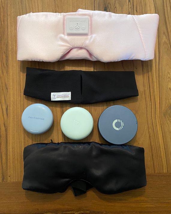 Six different styles of sleep headphones laid out on a table.