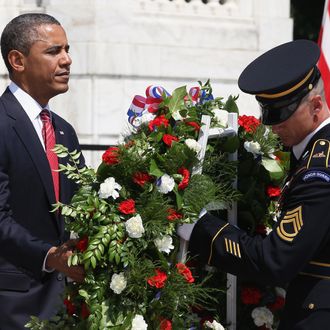 ARLINGTON, VA - MAY 28: U.S. President Barack Obama (L) positions a commemorative wreath during a ceremony on Memorial Day at the Tomb of the Unknowns at Arlington National Cemetery on May 28, 2012 in Arlington, Virginia. For Memorial Day President Obama is paying tribute to military veterans past and present who have served and sacrificed their lives for their country. (Photo by Mark Wilson/Getty Images)