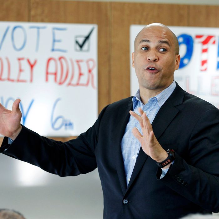 In this Wednesday, Oct. 10, 2012 photograph, Newark Mayor Cory Booker, center, addresses a gathering at a campaign event for Shelley Adler in Willingboro Township, N.J. Adler is challenging incumbent, former Philadelphia Eagles football star, Republican Rep. Jon Runyan in the 3rd Congressional District. New Jersey’s most recognizable politicians, Democrat Booker and Republican Gov. Chris Christie, are buttressing their national profile this election season, stumping for candidates eager to cash in on their growing popularity and name recognition while simultaneously earning their own political chits. The two men say they are being party loyalists and answering calls to help elect their chosen candidates. (AP Photo/Mel Evans)