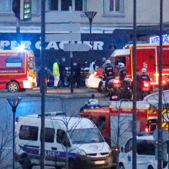 Rescue workers enter after police forces stormed the kosher store where a gunman held several hostages, in Paris, Friday Jan. 9, 2015.