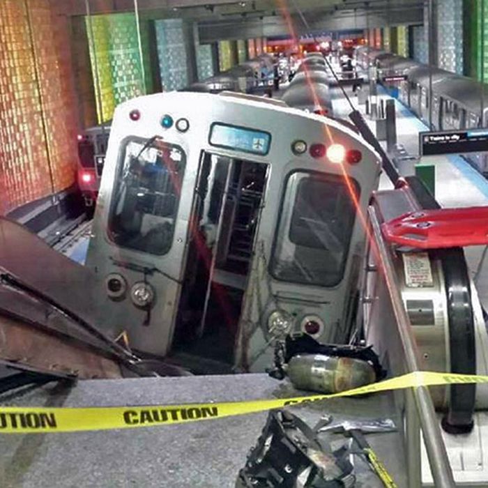 A Chicago Transit Authority train car rests on an escalator at the O'Hare Airport station after it derailed early Monday, March 24, 2014, in Chicago. More than 30 people were injured after the train 