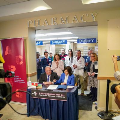 Gov. Kathy Hochul signs the Safe Harbor for All legislation alongside Health Commissioner James McDonald, at Albany Health Center in Albany, N.Y., on Tuesday, March 19, 2024. (Cindy Schultz/The New York Times)