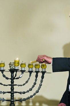 David Ben-Gurion's grandson Yariv Ben-Eliezer lights the Menorah during the Hanukkah reception at White House in Washington, DC, December 15, 2008.     AFP PHOTO/Jim WATSON (Photo credit should read JIM WATSON/AFP/Getty Images)