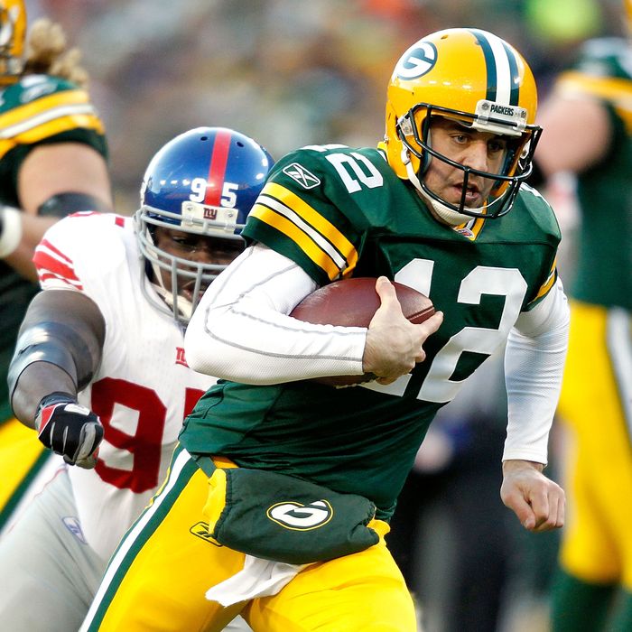 Aaron Rodgers #12 of the Green Bay Packers is chased out of the pocket against the New York Giants at Lambeau Field on December 26, 2010 in Green Bay, Wisconsin. 