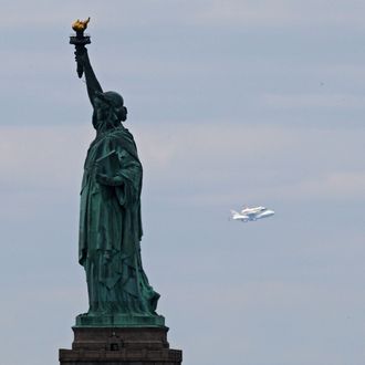 NEW YORK, NY - APRIL 27: Space shuttle Enterprise, mounted atop a 747 shuttle carrier aircraft, flies past the Statue of Liberty prior to landing at John F. Kennedy International Airport on April 27, 2012 in New York City. Enterprise, which was flown from Washington, DC, will eventually be put on permanent display at the Intrepid Sea, Air and Space Museum. (Photo by Michael Heiman/Getty Images)