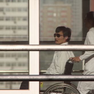 Chinese activist activist Chen Guangcheng (L) is seen in a wheelchair pushed by a nurse at the Chaoyang hospital in Beijing on May 2, 2012. 