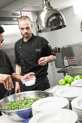 Iron Chef Jose Garces seasons fava beans as his sous chef (Louis) and Chef Paul Kahan look on.