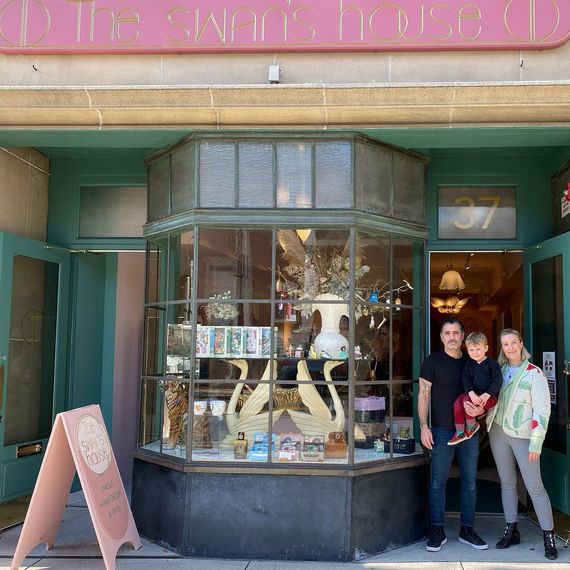 A family standing in front of a vintage furniture shop. 