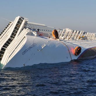 GIGLIO PORTO, ITALY - JANUARY 14: The cruise ship Costa Concordia lies stricken off the shore of the island of Giglio, on January 14, 2012 in Giglio Porto, Italy. More than four thousand people were on board when the ship hit a sandbank. At least 3 people have been confirmed dead and another 50 are unaccounted for. (Photo by Laura Lezza/Getty Images)