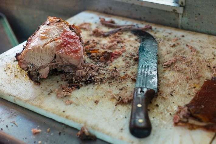 As is traditional, the lechon is chopped with a machete.