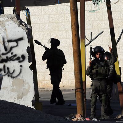 A member of the Israeli security forces flashes the sign for victory during clashes with Palestinian youths from the Jalazoun refugee camp at the entrance of the Jewish West Bank settlement Beit El, north of Ramallah, following a march by Palestinian demonstrators against Israeli restrictions on the Al-Aqsa mosque and against Jewish settlements in the West Bank on October 24, 2014. 