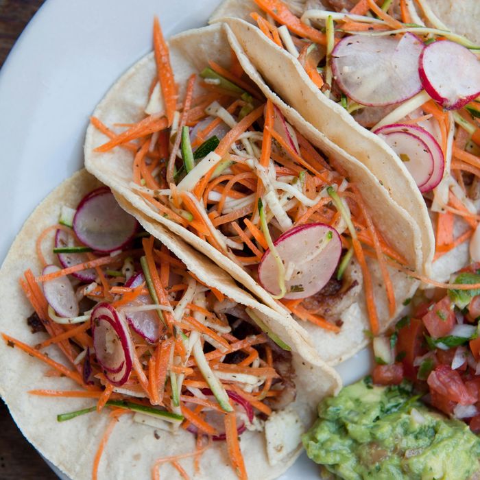 Pork belly tacos with radishes, carrots, zucchini salad, and oregano mojo.
