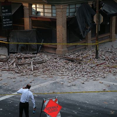 NAPA, CA - AUGUST 24: A reporter surveys the scene of a building collapse following a reported 6.0 earthquake on August 24, 2014 in Napa, California. A 6.0 earthquake rocked the San Francisco Bay Area shortly after 3:00 am on Sunday morning causing damage to buildings and sending at least 70 people to a hospital with non-life threatening injuries. (Photo by Justin Sullivan/Getty Images)