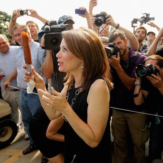 DES MOINES, IA - AUGUST 12: Republican presidential candidate Rep. Michele Bachmann (R-MN) shows off her foot-long corn dog as photographers take her picture at the Iowa State Fair August 12, 2011 in Des Moines, Iowa. Unlike any of the other GOP hopefuls at the fair, Bachmann arrived 30 minutes late for her scheduled speech and spoke for less than three minutes of her alloted 20 minutes then left on a golf cart guarded by state troopers. All of the Republican presidential hopefuls are visiting the fair ahead of Saturday's Iowa Straw Poll to greet voters and engage in traditional Iowa campaigning rituals. (Photo by Chip Somodevilla/Getty Images)