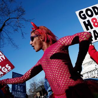 New York based drag performer Queen dances during a rally while surrounded by protesters from the conservative Westboro Baptist Church in front of the U.S. Supreme Court on March 26, 2013 in Washington, DC. The Supreme Court is hearing arguments March 26, in California's proposition 8, the controversial ballot initiative that defines marriage only between a man and a woman.