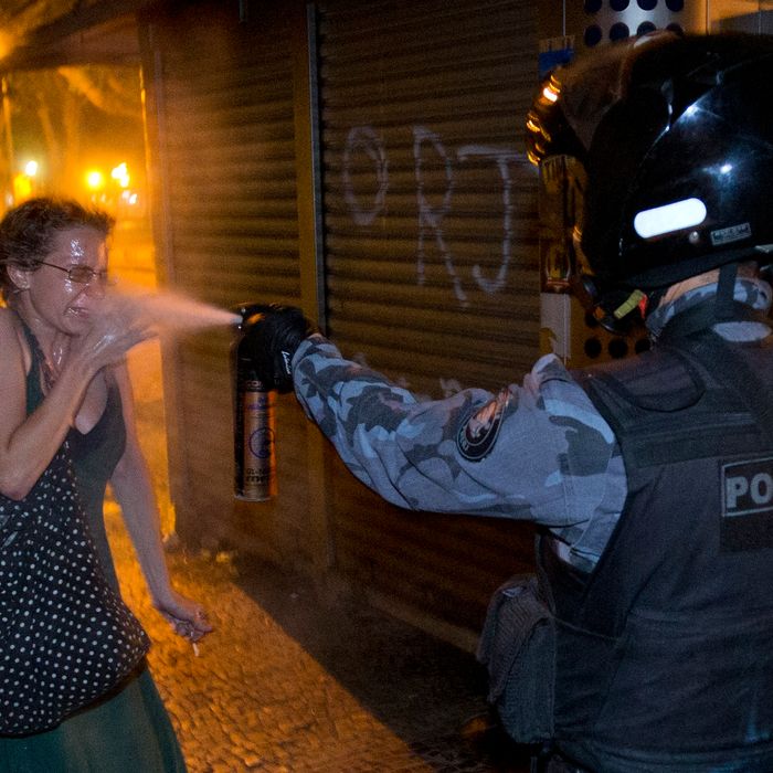 A military police peper sprays a protester during a demonstration in Rio de Janeiro, Brazil, Monday, June 17, 2013. Protesters massed in at least seven Brazilian cities Monday for another round of demonstrations voicing disgruntlement about life in the country, raising questions about security during big events like the current Confederations Cup and a papal visit next month. ((AP Photo/Victor R. Caivano)