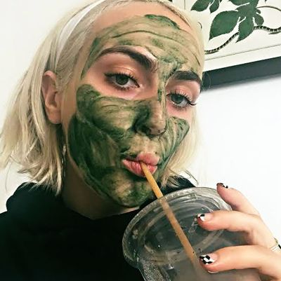 The author in her Chlorophyll mask drinking a green juice.
