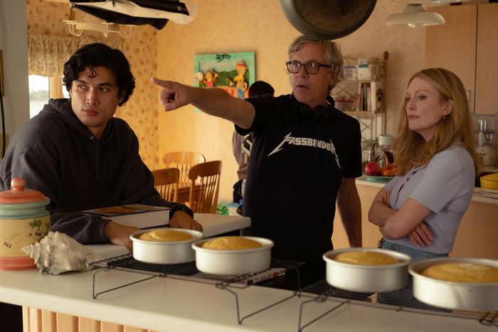Charles Melton, Todd Haynes, and Julianne Moore stand in front of four pineapple upside-down cakes.