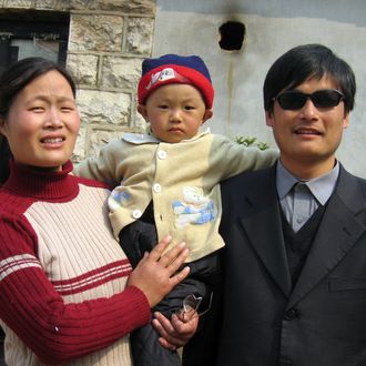 A picture dated March 28, 2005 shows blind activist Chen Guangcheng (R) with his wife and son Chen Kerui outside the home in Dondshigu village, northeast China's Shandong province. Chen, who gained worldwide fame for exposing abuses in China's 