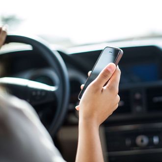 15 Jun 2014, San Francisco, California, USA --- Woman at wheel of car using phone --- Image by ? Wonwoo Lee/Corbis