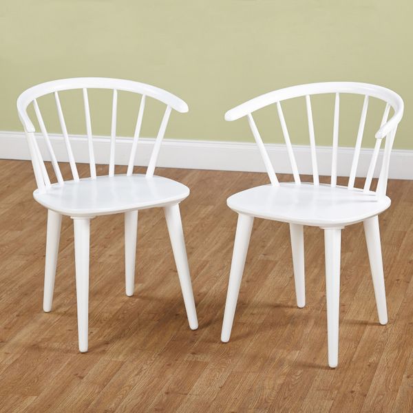 A 2-chair set of Florence Dining Chairs in bright white with low, spoked backs and slightly splayed legs, shown in a room with a light wood floor and a pale green wall. The Strategist - 33 Things on Sale You’ll Actually Want to Buy: From Adidas to Le Creuset
