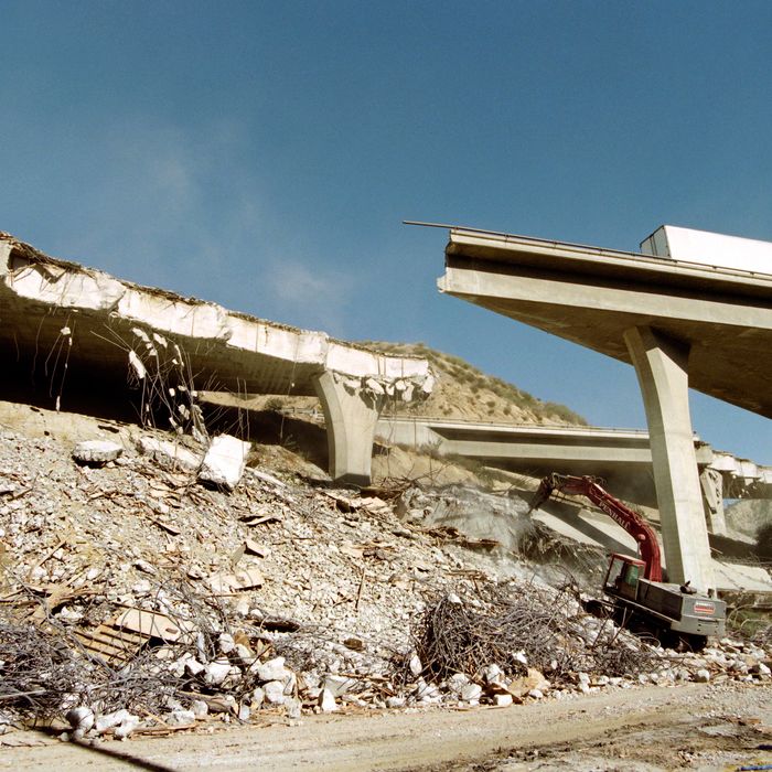 Heavy equipment prepares for moving portions of Interstate 5 as an abandoned truck rests on the dmaged structure on January 18, 1994. The highway collapsed January 17 when an earthquake hit the region, causing 7 billion USD in damage in the area. AFP PHOTO TIM CLARY (Photo credit should read TIM CLARY/AFP/GettyImages)